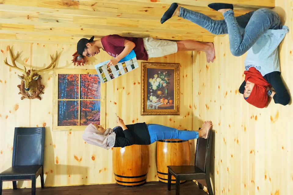 A room with wooden walls and furniture where people appear upside-down due to the perspective of the photo.