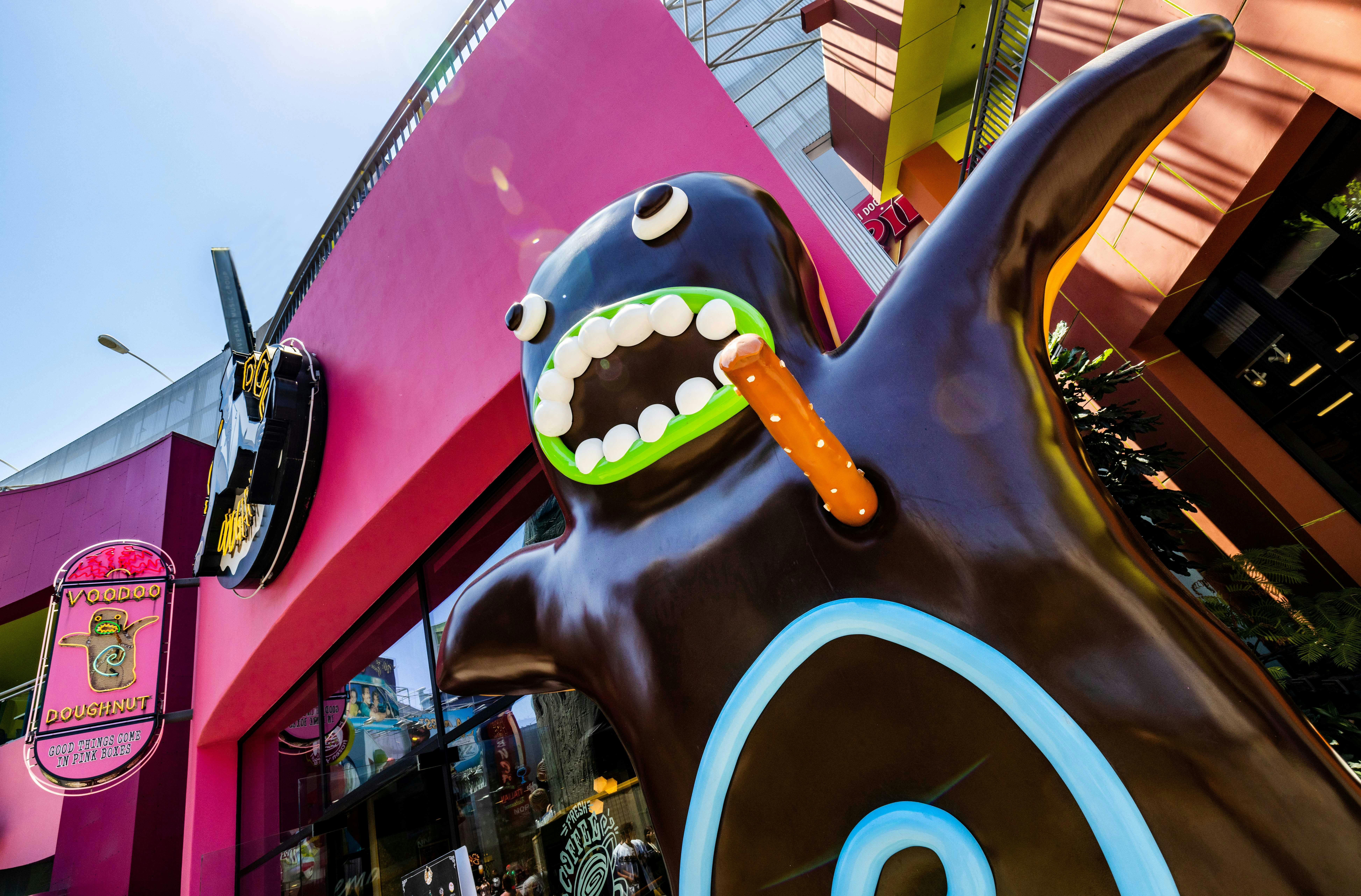 色とりどりの都会のアウトドアを舞台に、目が大きく、舌の広い黒い怪物の巨大な気まぐれな彫刻。