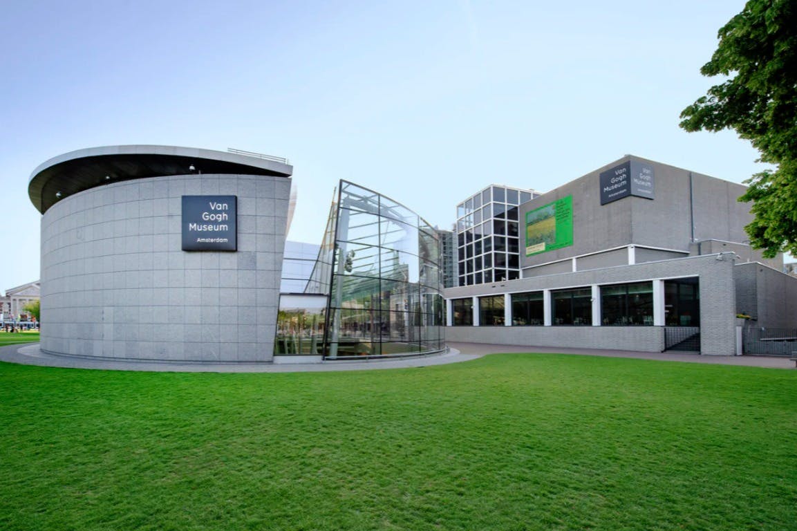 阿姆斯特丹梵高博物馆的现代建筑，带有玻璃入口和绿草。