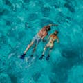 ムエハレス島の水晶のような水を楽しむカップル。