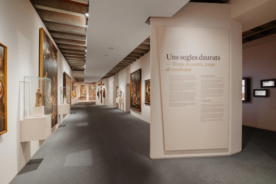 Art gallery hallway featuring various paintings, sculptures, and a descriptive wall text titled "A Golden Age."