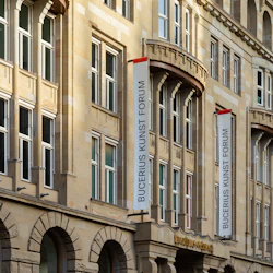 Fasaden på Bucerius Kunst Forum har banderoller, stora fönster och välvda ingångar, med en blandning av traditionell och modern arkitektur.