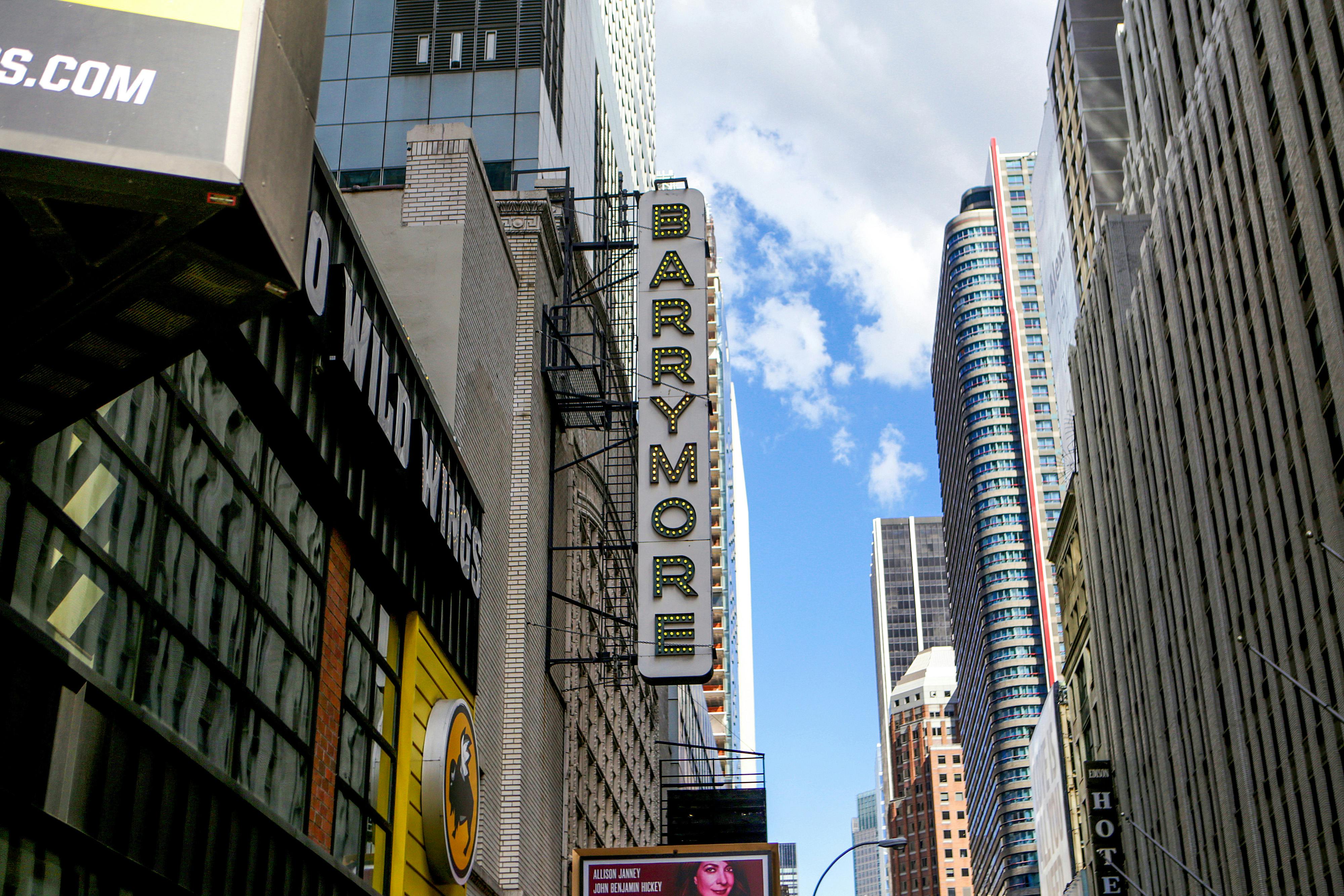 Tall buildings in a city with a vertical sign reading "Barrymore" and a partially visible yellow sign for Buffalo Wild Wings.