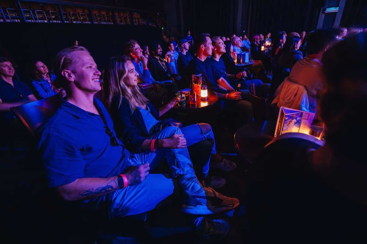 Μέλη του κοινού που γελούν με τον Boom