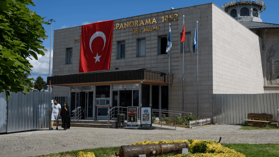 The Turkish Panorama 1453 History Museum displays the Turkish flag and has three flagpoles at the entrance.