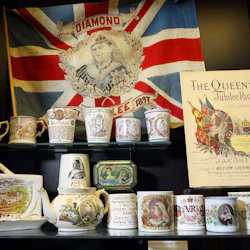 Array av viktorianska minnessaker för drottning Victorias Diamond Jubilee, inklusive muggar, en tekanna, tenn, flagga och en affisch.