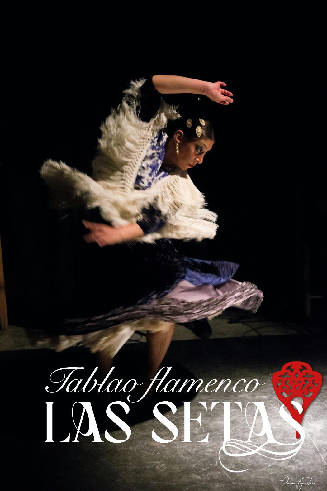 무대에서 공연하는 미드 모션의 플라멩코 댄서로, 프린지 숄과 전통 드레스를 입고 있습니다. 'Tablao flamenco LA COENTA' 라는 문구가 적혀 있습니다.
