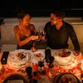 Романтический ужин на роскошной яхте Пара поднимает тост с бокалом красного вина