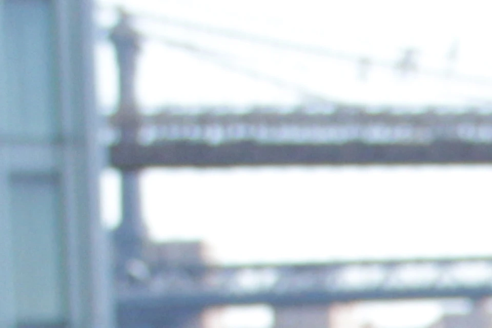 Three women stand with bicycles near a waterfront, smiling and chatting. A bridge and urban background are visible.