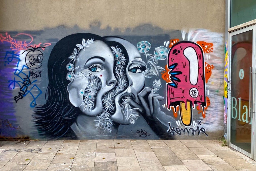 Œuvre d'art de rue représentant 2 femmes et une glace.