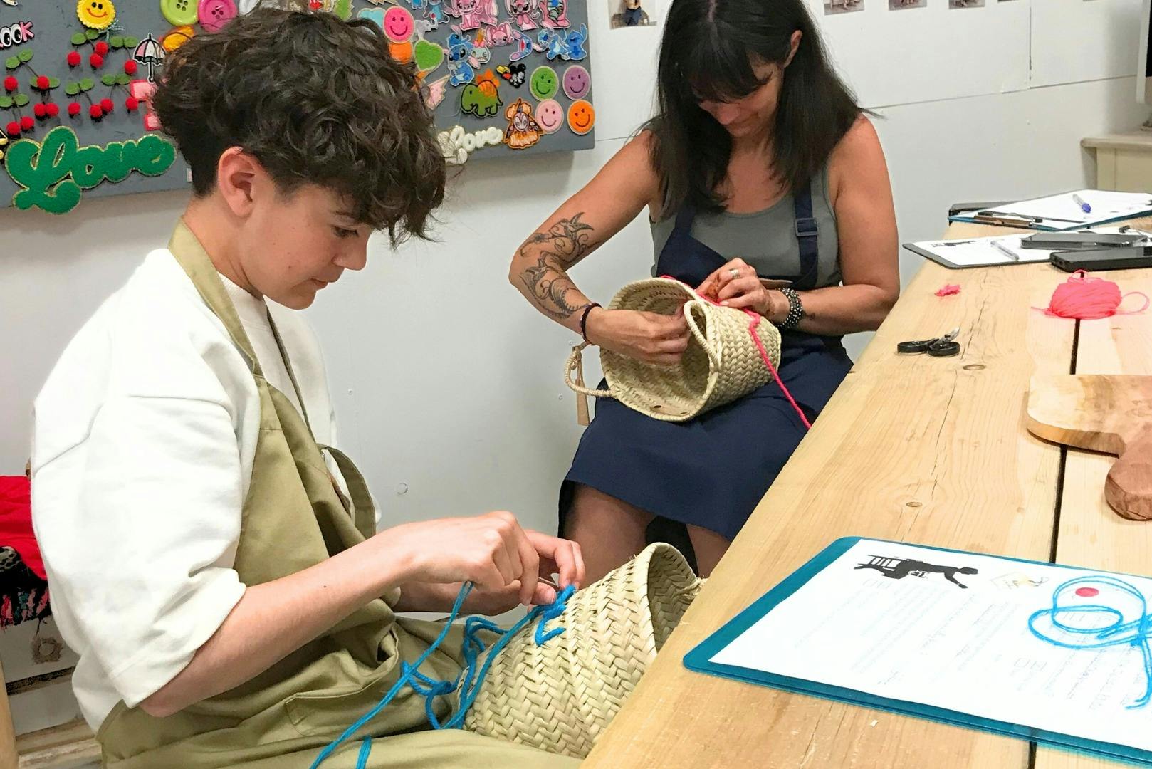 Δύο άνθρωποι κάθονται σε ένα τραπέζι πλέκοντας καλάθια από άχυρο. Το φόντο έχει πολύχρωμα χαμογελαστά αυτοκόλλητα και μια πινακίδα "love".