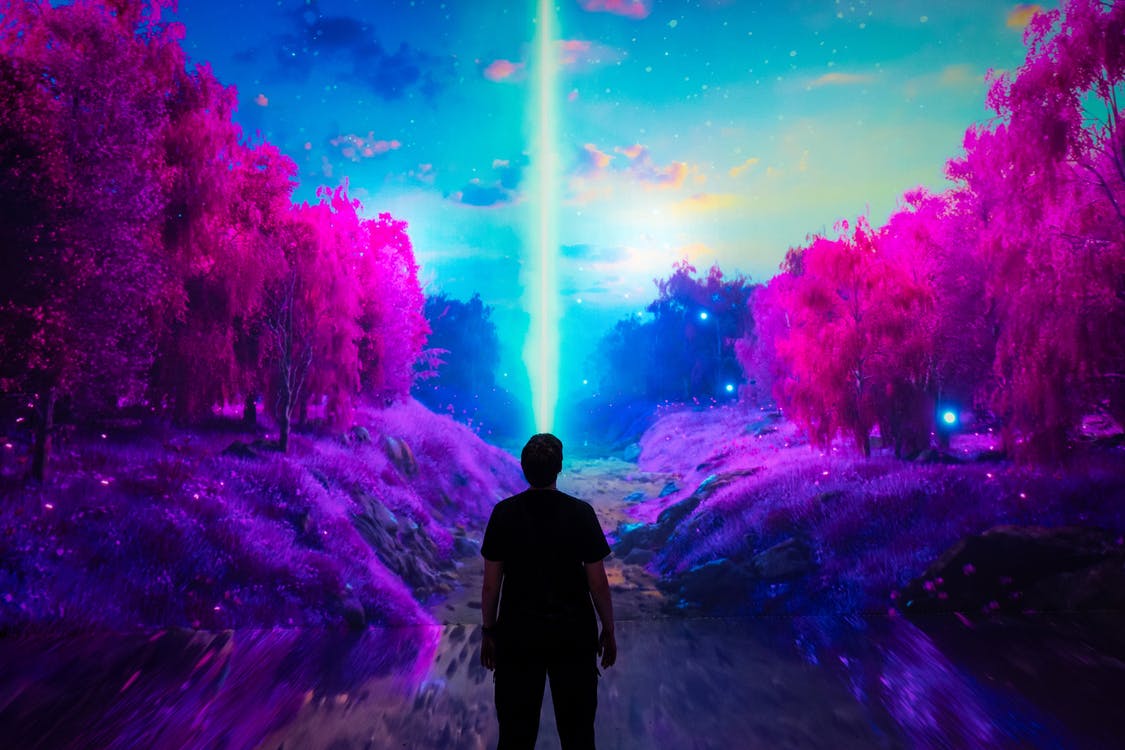 Menschen gehen über einen Zebrastreifen in einer dunklen, futuristischen Stadtlandschaft mit hellen Neonlichtern und nebliger Atmosphäre.