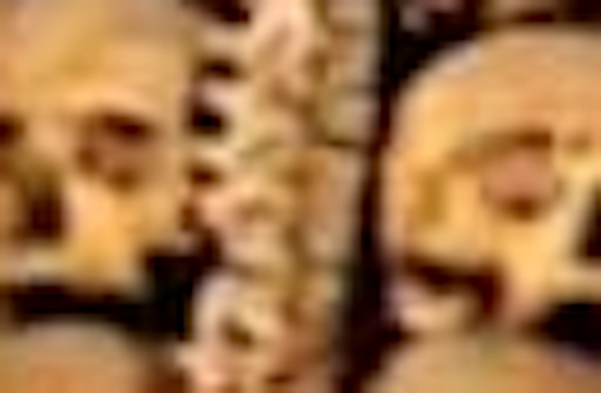 Walls and archway of a room decorated with arranged human skulls and bones, forming intricate patterns and structures.