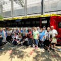 Tour em grupo posando em frente ao ônibus de turismo do crime