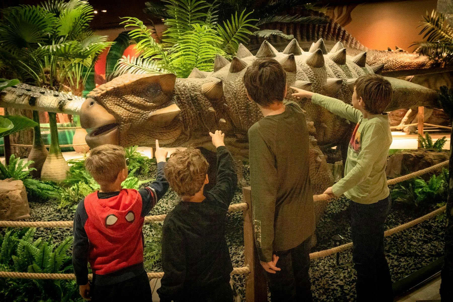 Kinderen wijzen naar dinosaurus
