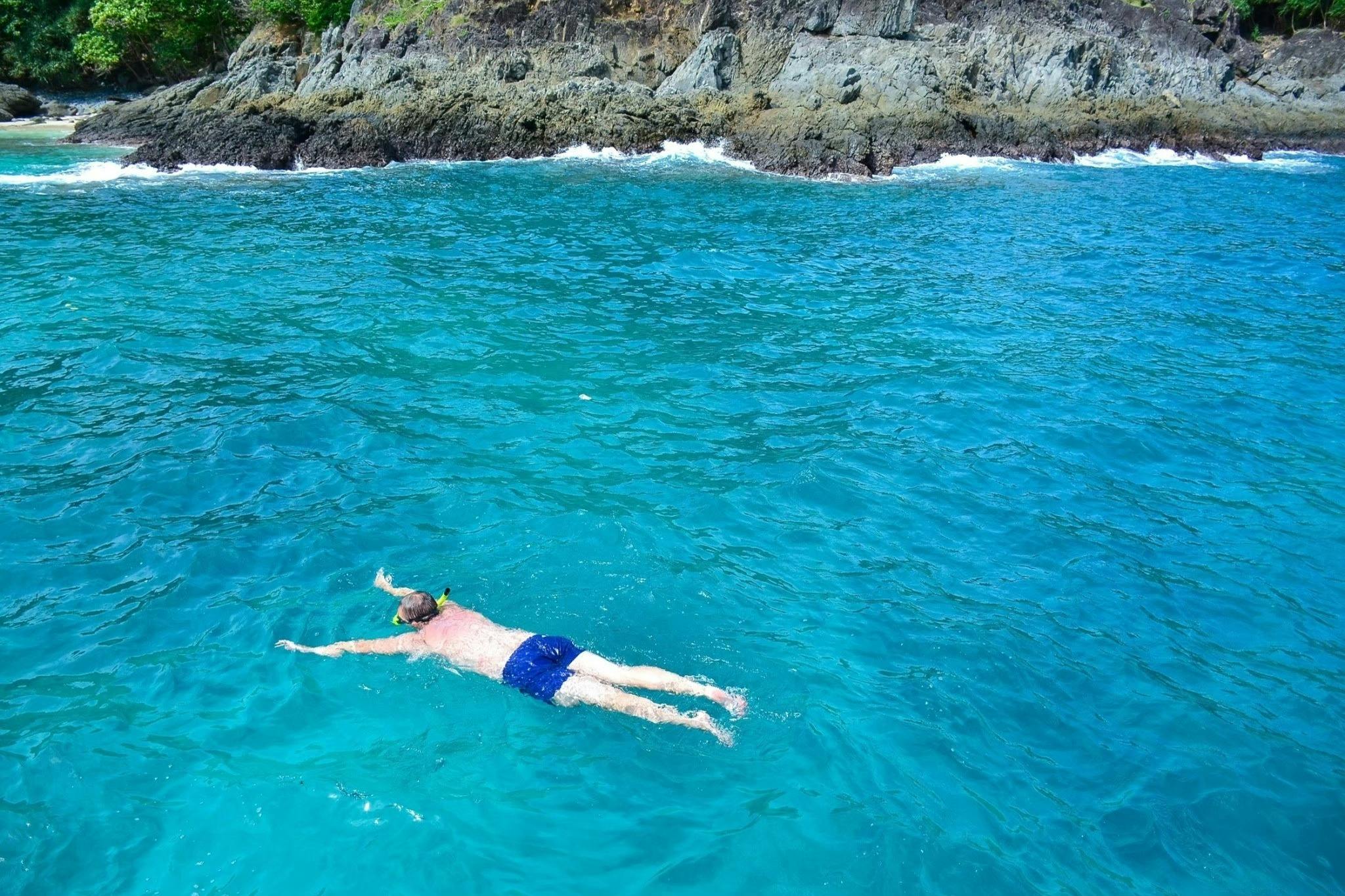 Les récifs coralliens abondants et les poissons enjoués accueillent chaque plongeur avec masque et tuba.