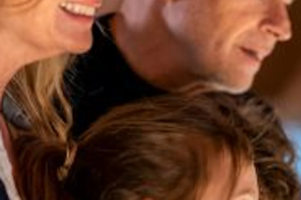 A family of three observing an exhibit in a museum with arched brick ceilings.