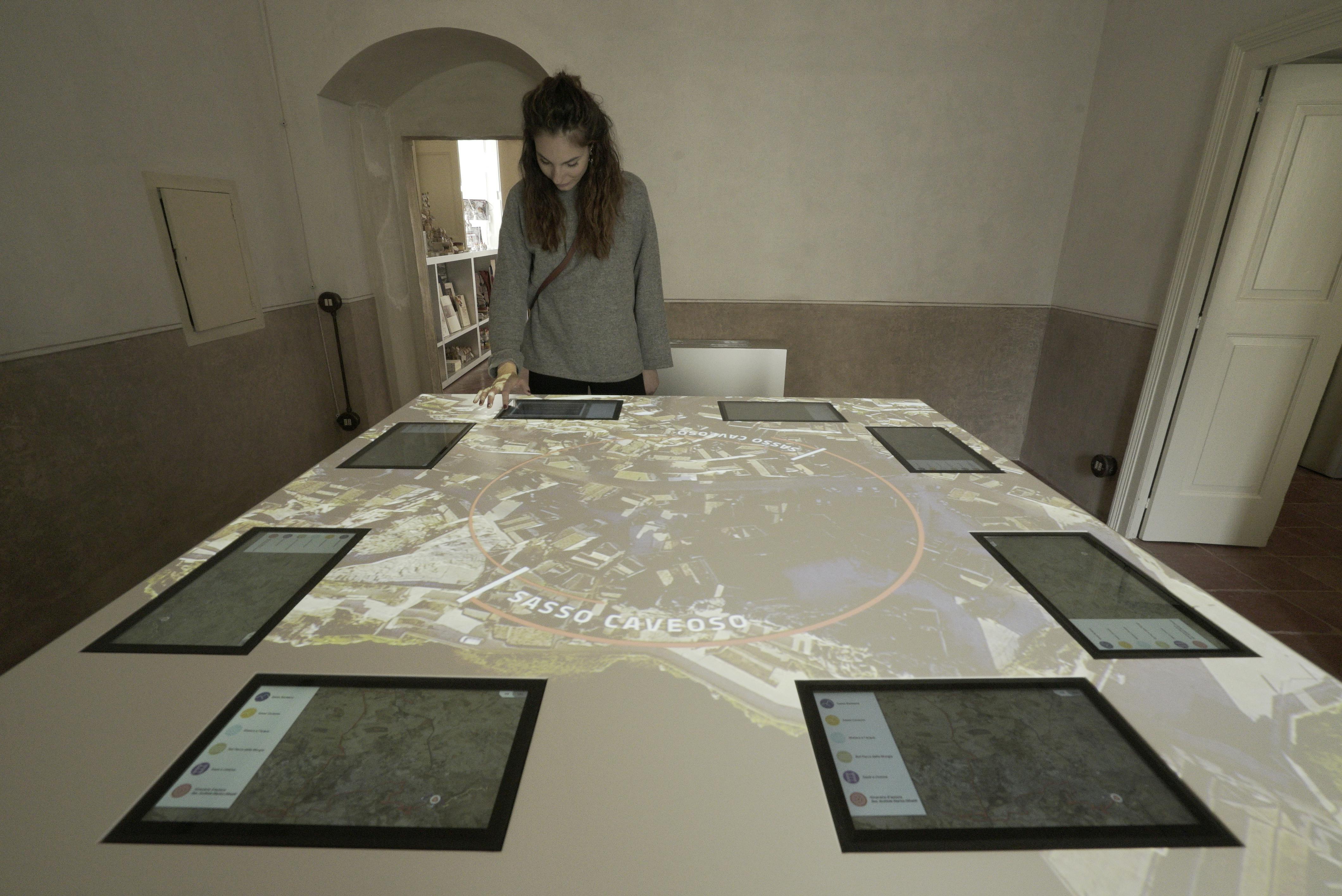 A woman looks at a large table displaying a map with the text 