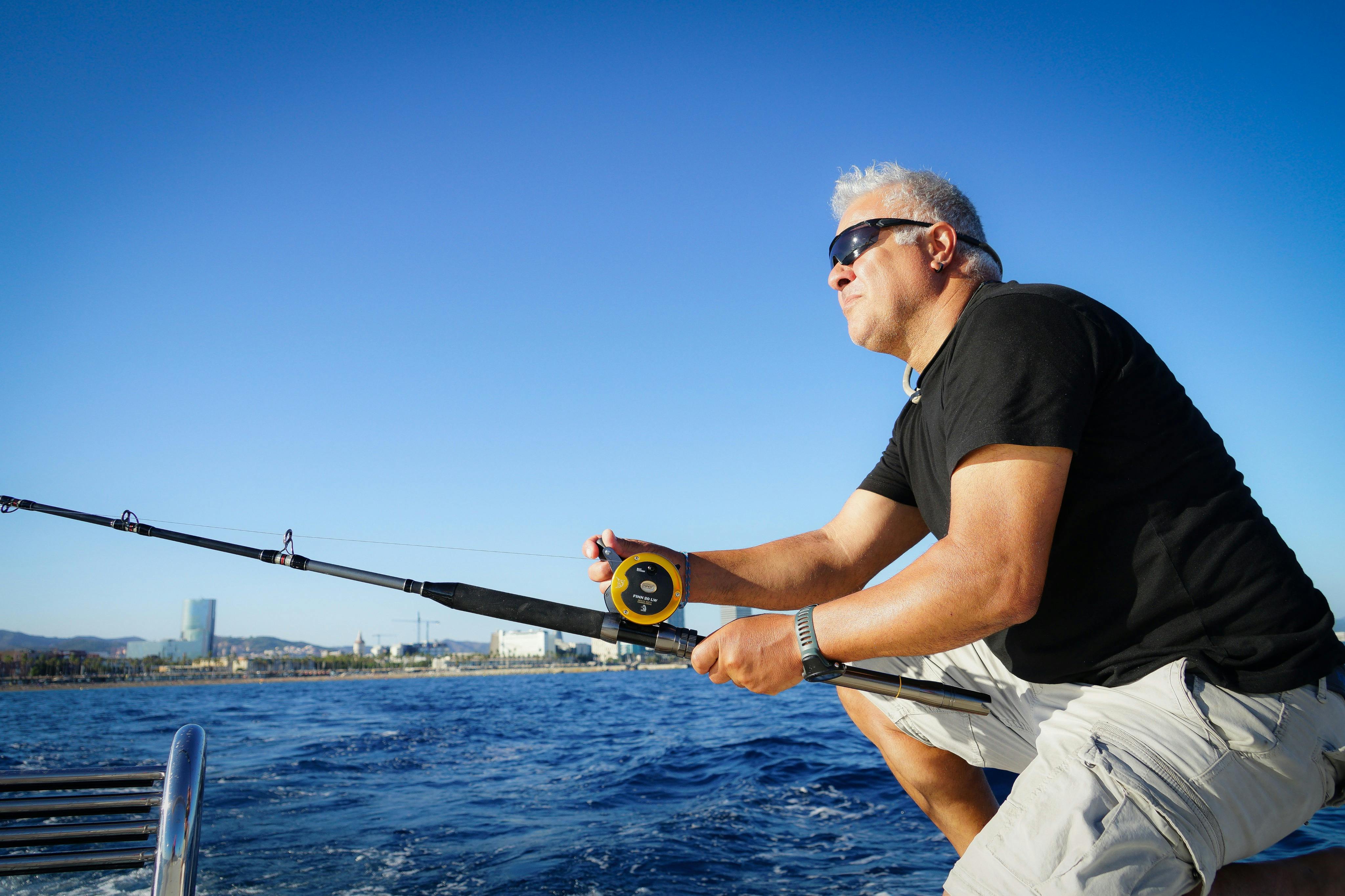 Muž, který se dívá na obzor a drží rybářský prut.
