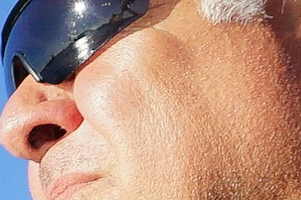 A man looking at the horizon and holding a fishing rod.