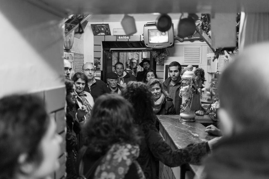 穆拉里亚（ Mouraria ）的一家当地小酒馆，一群人在等待「Ginjinha」时听导游讲解。