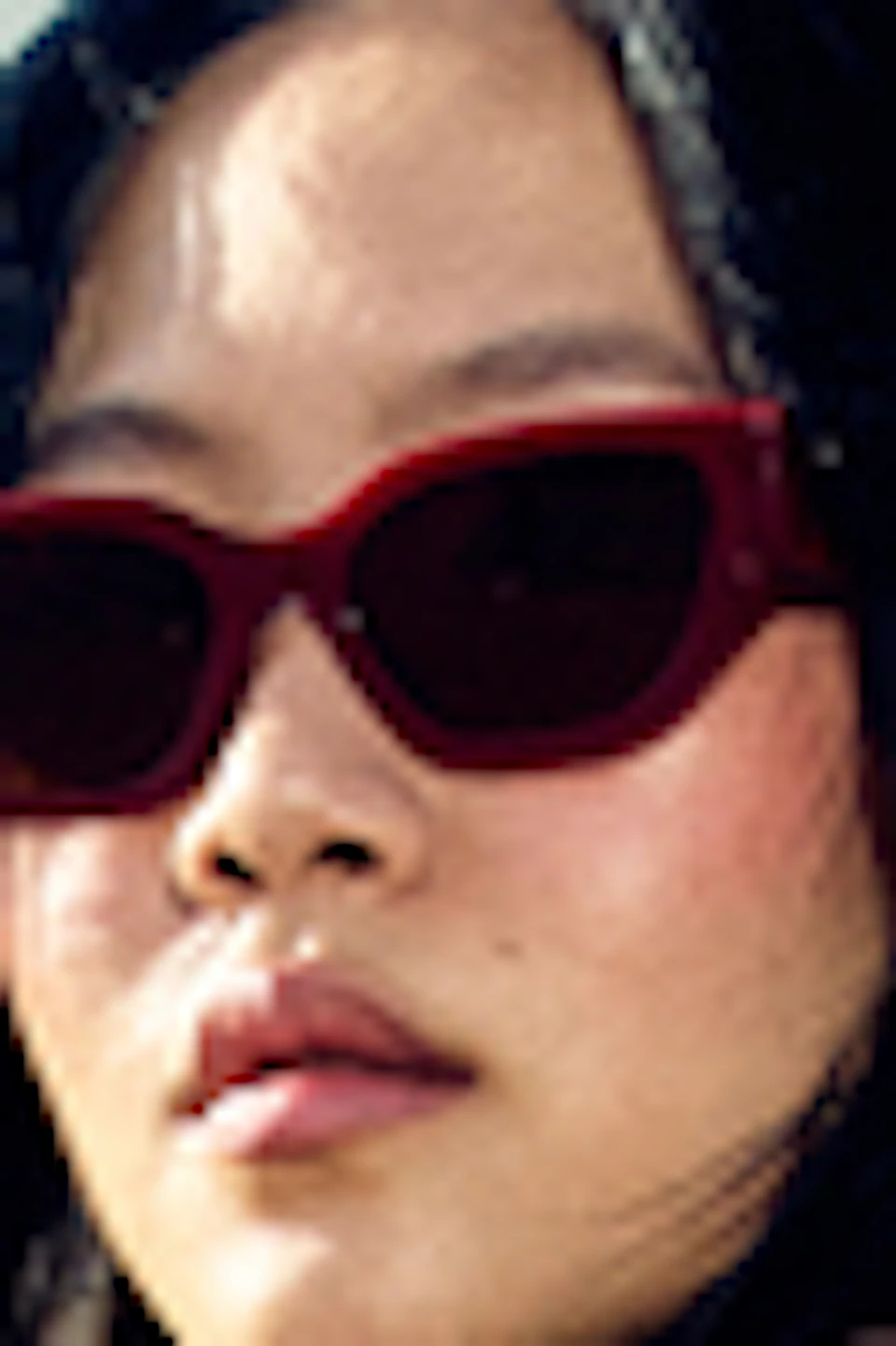 A person wearing a leather jacket and sunglasses stands in front of a bus with "La Roca Village" written on its side.