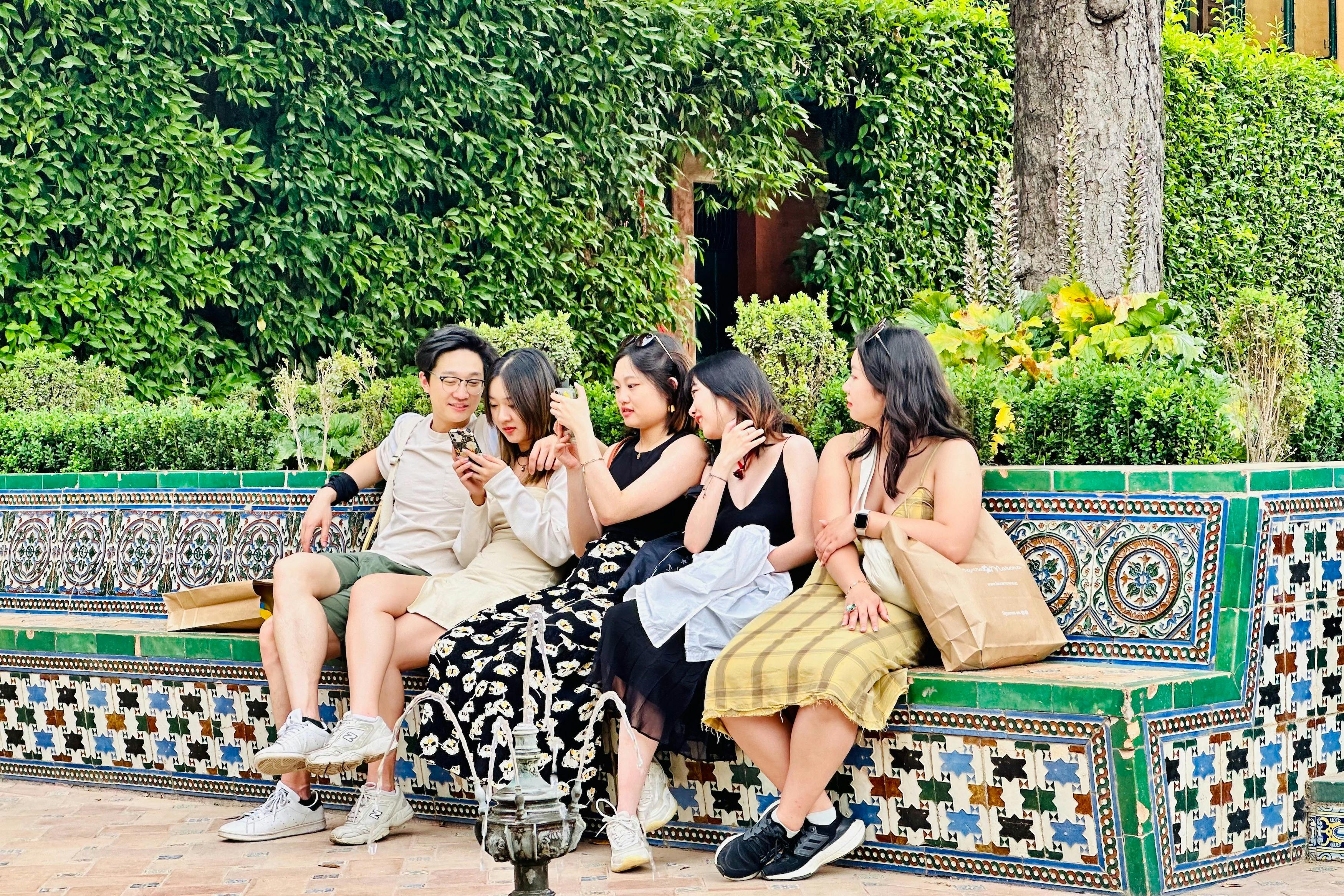 Besøgende, der nyder haverne i Alcazar efter Sevilla-turen