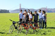 Un groupe d'amis pose devant le pont avec leurs vélos