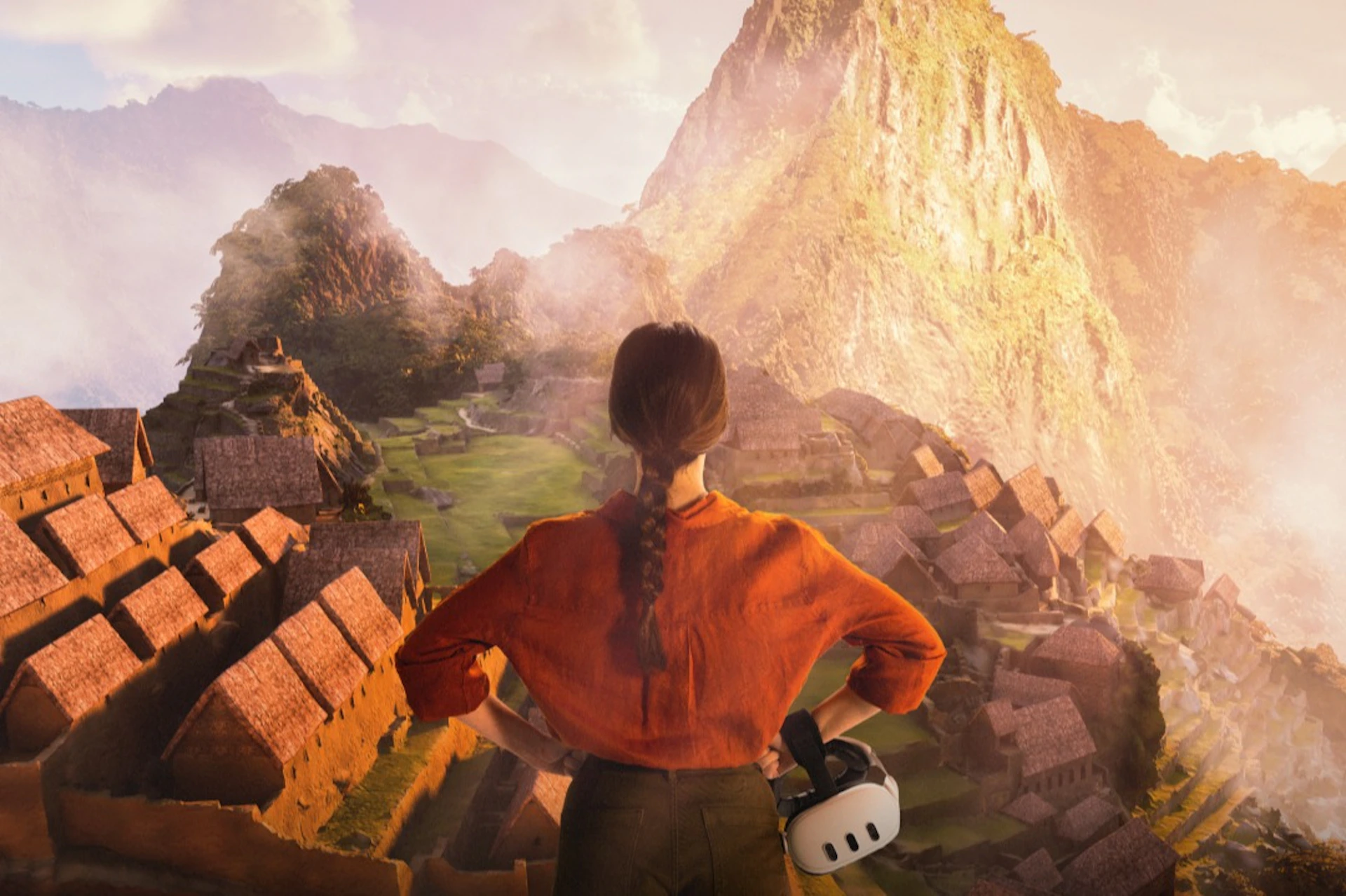 A person in an orange shirt with a braided ponytail stands overlooking the ancient structures of Machu Picchu at sunrise, holding a VR headset.