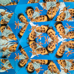 A kaleidoscopic image of a smiling person making peace signs, with repeated reflections creating a geometric pattern.