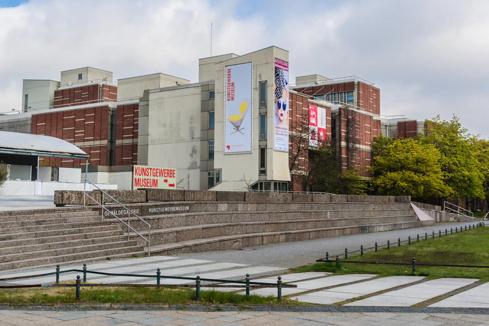 Exterior of the Kunstgewerbemuseum, a modern brick and concrete building with large banners and signage.
