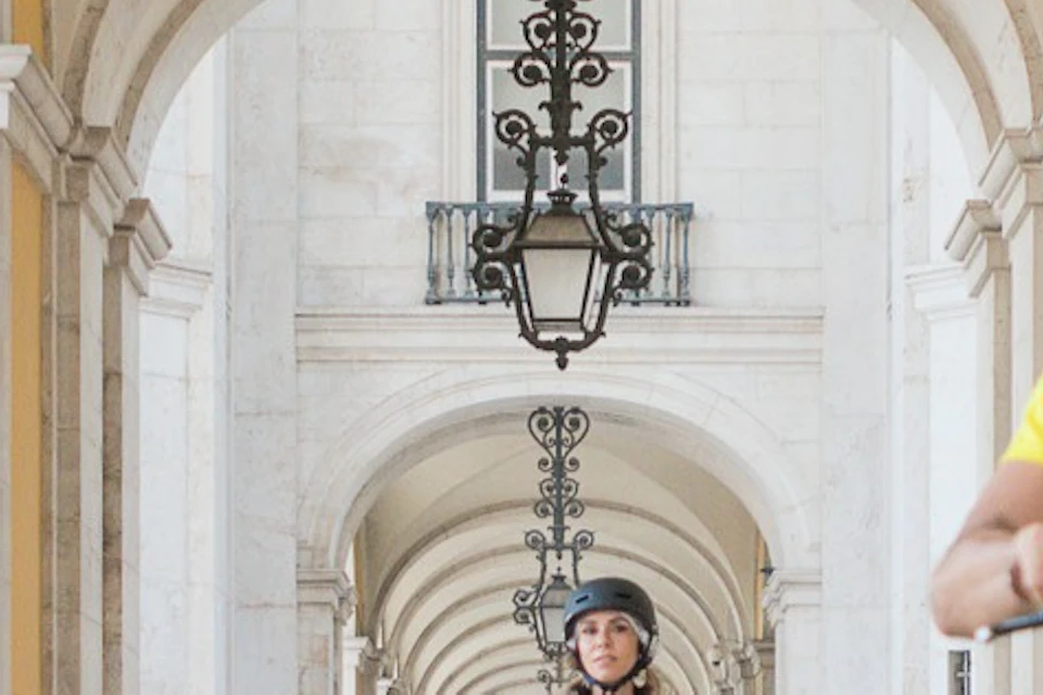 Tourists enjoying an E-Bike Tour in Lisbon with a stop at Commerce Square.