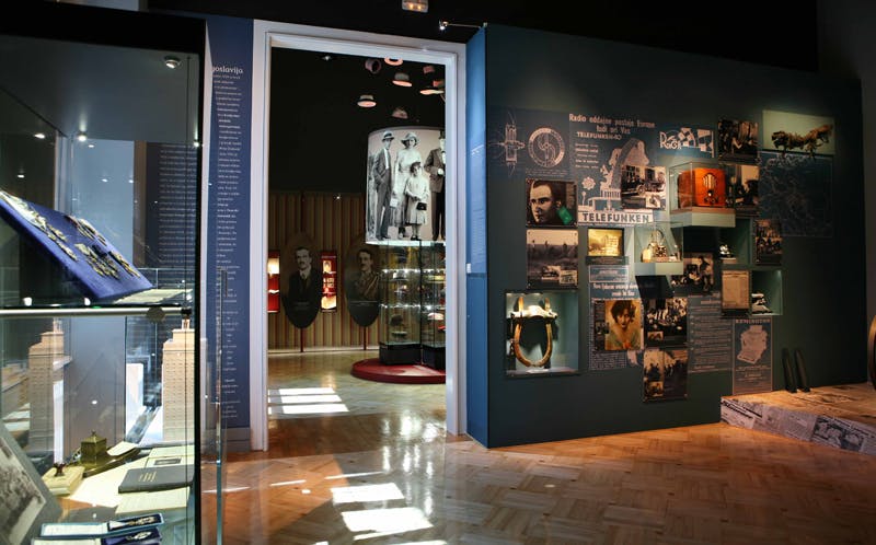 Expozice muzea s retro fotografiemi, artefakty a historickými informacemi na stěnách a ve vitrínách.