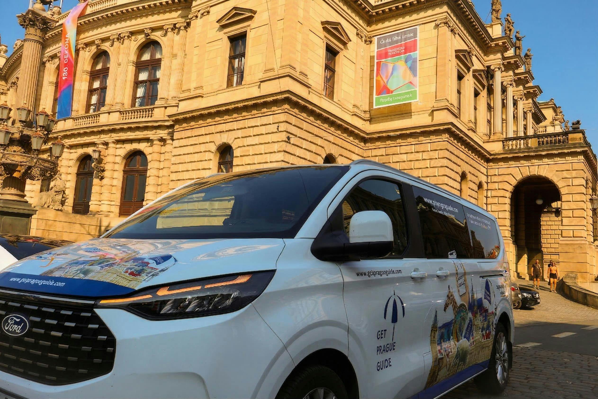 Ένα βαν με το κείμενο "Get Prague Guide" σταθμευμένο μπροστά από ένα ιστορικό κτίριο με τοξωτά παράθυρα και ένα πανό.