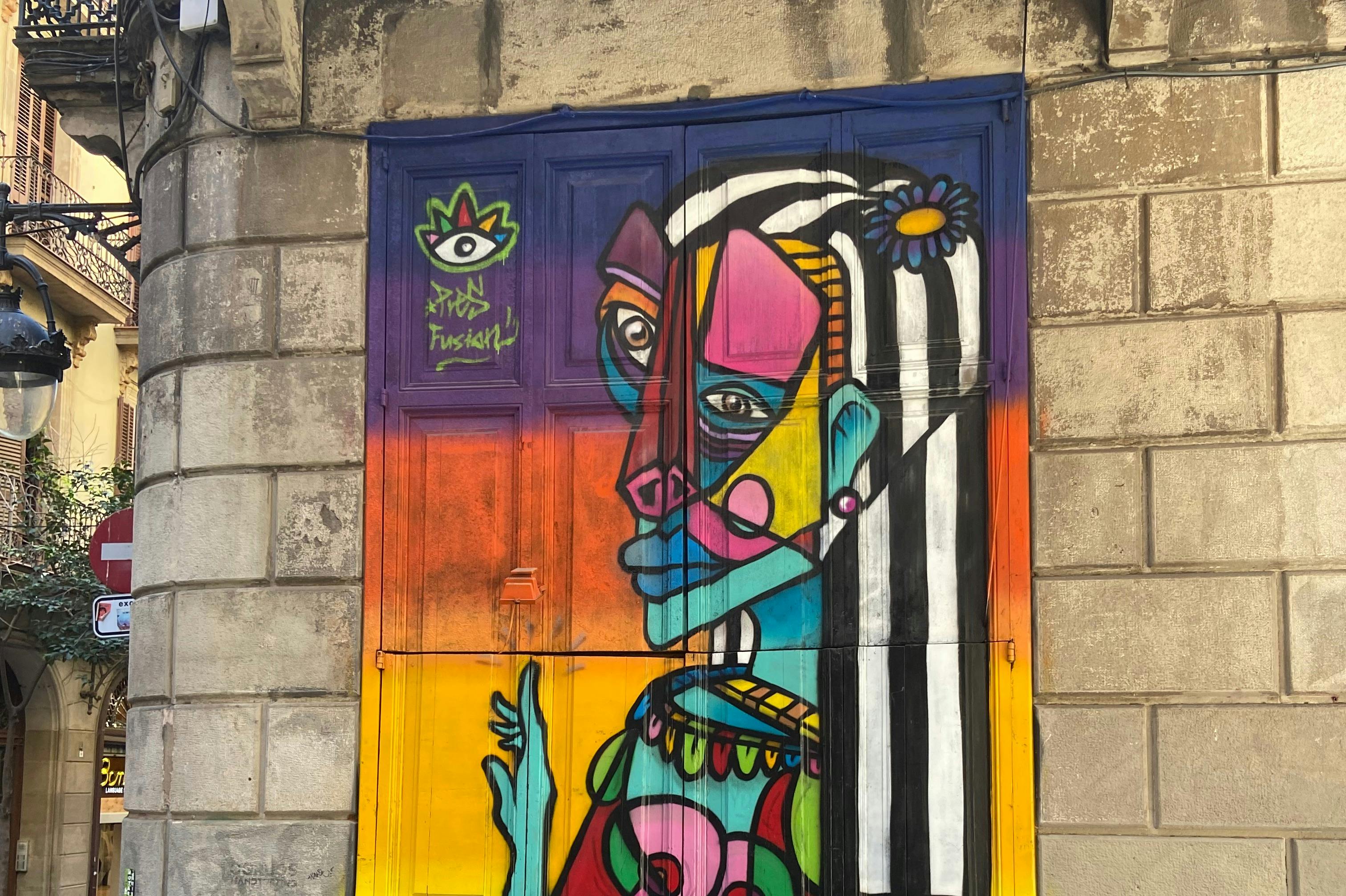 Art de rue cubiste à la Picasso peint sur la grande porte en bois d'un bâtiment du 19e siècle à Barcelone.