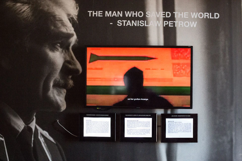 A display with Stanislaw Petrow's portrait, a screen showing a missile, and three panels of text beneath it.