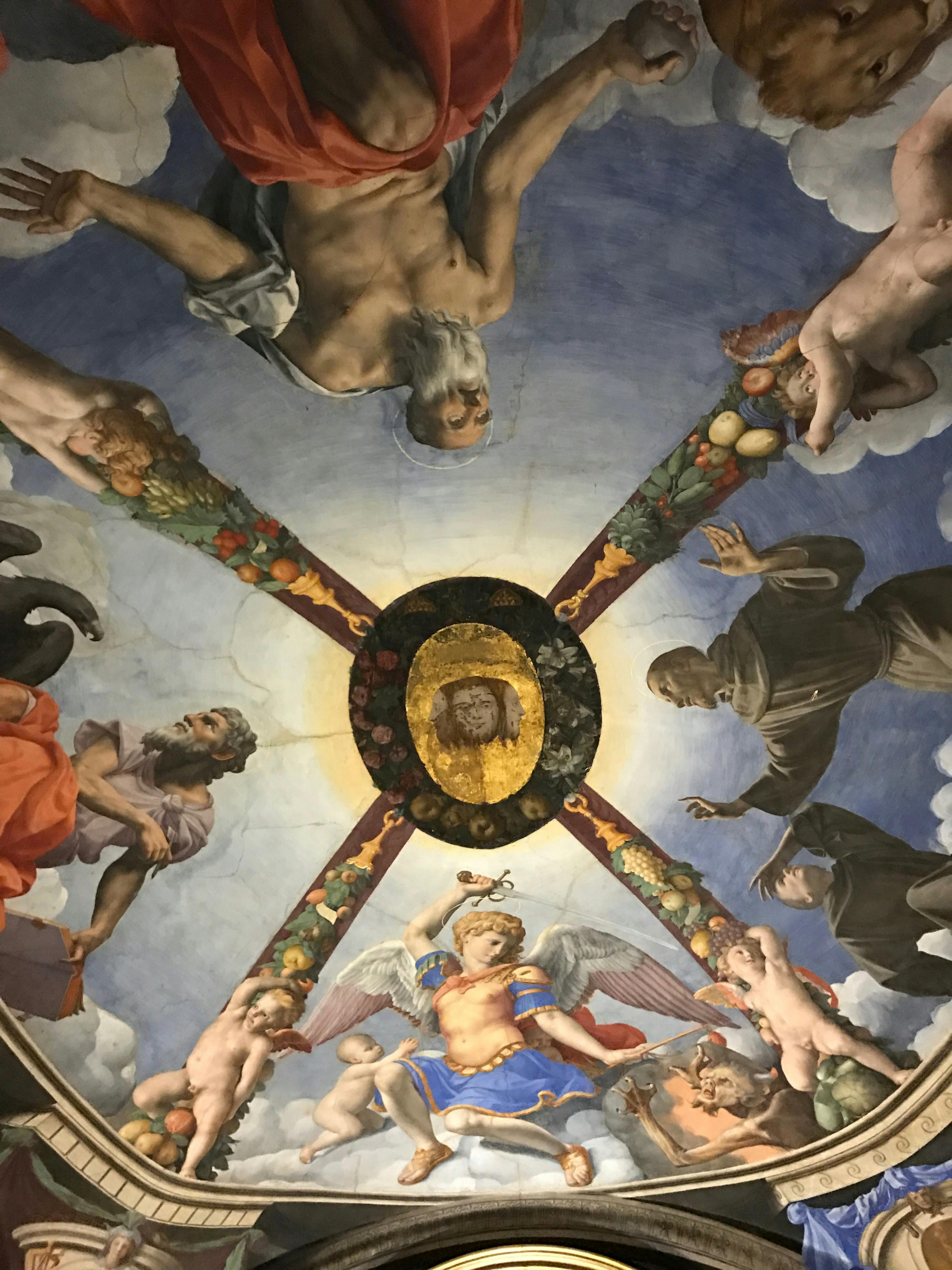 Un affresco raffigura esseri celestiali, tra cui un anziano uomo barbuto, un angelo con le ali e figure religiose che circondano un medaglione centrale.