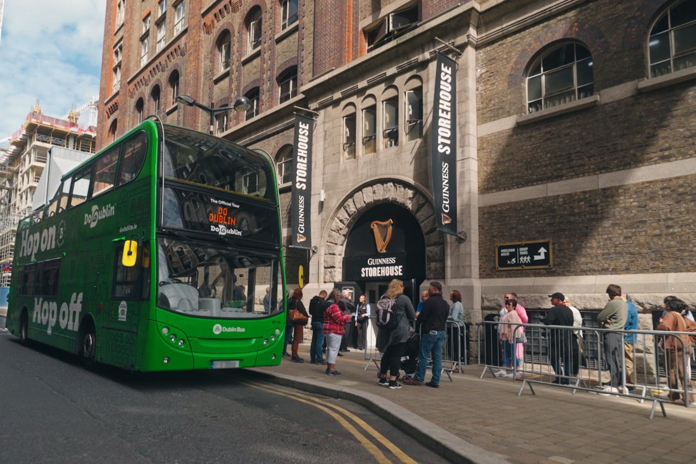 绿色巴士停在棕色建筑前