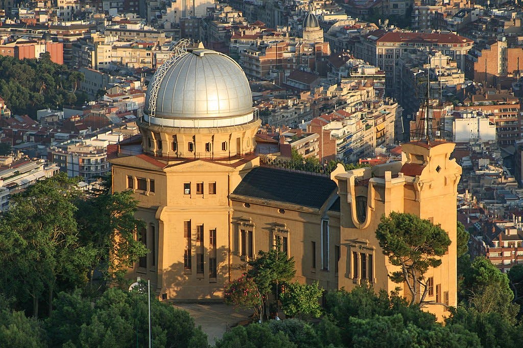 丘の上に大きなドームが設置された展望台で、多くの建物を背景に人口密度の高い都市部を見下ろしています。
