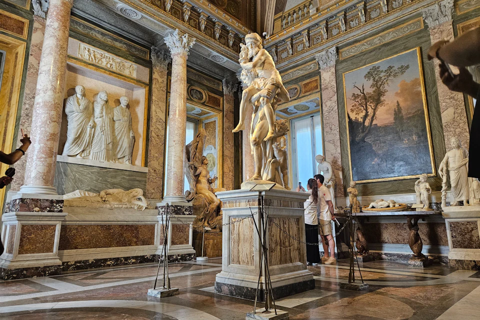 Pause before the sculpture of Aeneas, Anchises, and Ascanius, another one of Bernini's masterpieces inside the gallery.