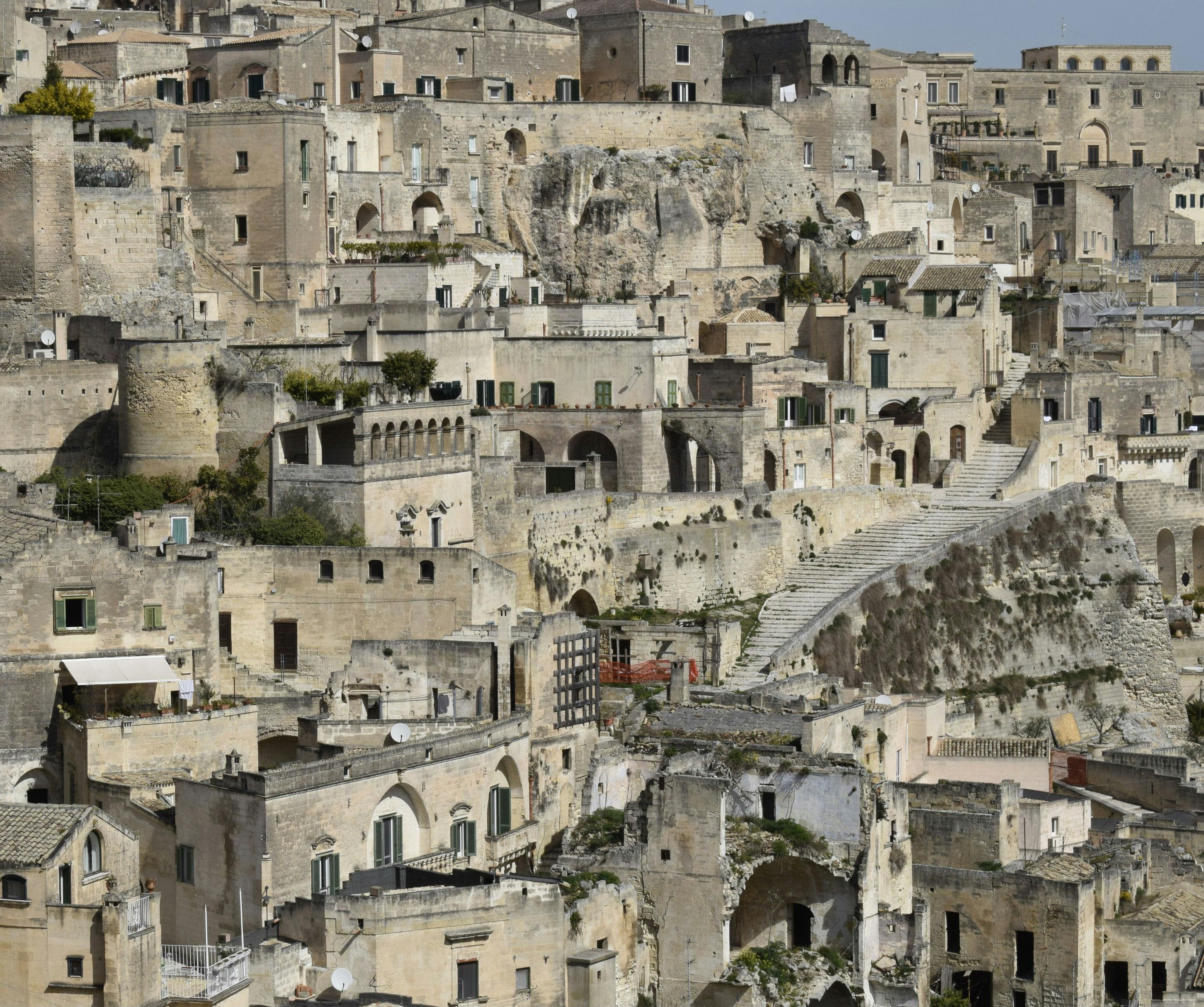 Πυκνό σύμπλεγμα αρχαίων πέτρινων κτιρίων με στενά κλιμακοστάσια και βεράντες, χτισμένα στην πλαγιά ενός λόφου.