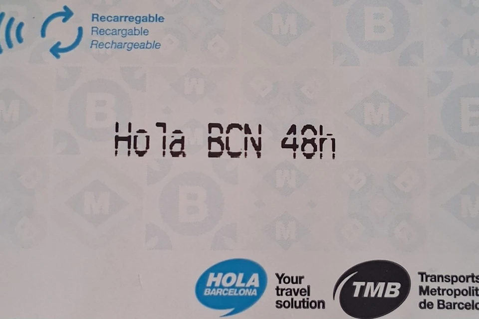 Close-up of a ticket labeled 'Hola BCN 48h' with logos and text indicating it's a 48-hour travel pass for Barcelona.