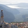 Invité prenant une photo depuis un point élevé à Delphes, observant la vallée d'Itea