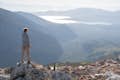 Gast maakt een foto vanaf een hoog punt bij Delphi, kijkend naar de vallei van Itea