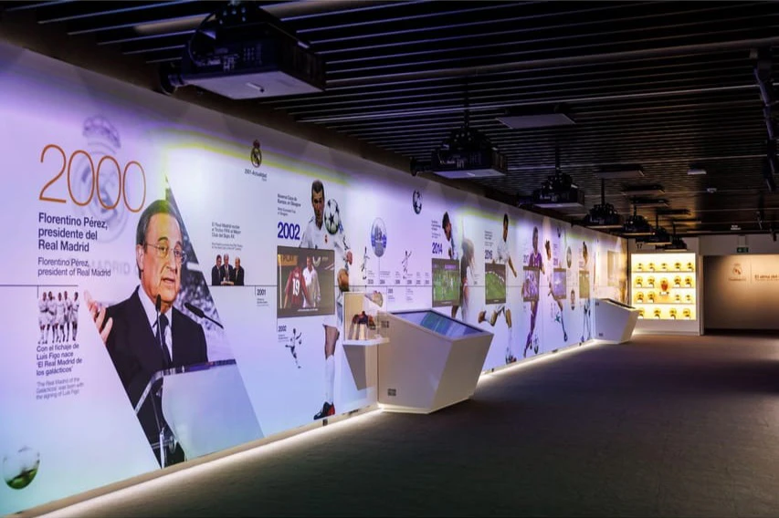 A wall display featuring images, text, and memorabilia of Florentino Pérez and significant events in Real Madrid history.