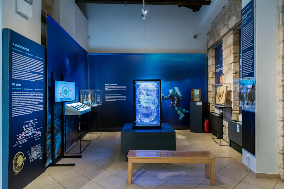 Exhibit room with displays of underwater exploration artifacts, a glowing scientific diagram, and a wooden bench in the center.