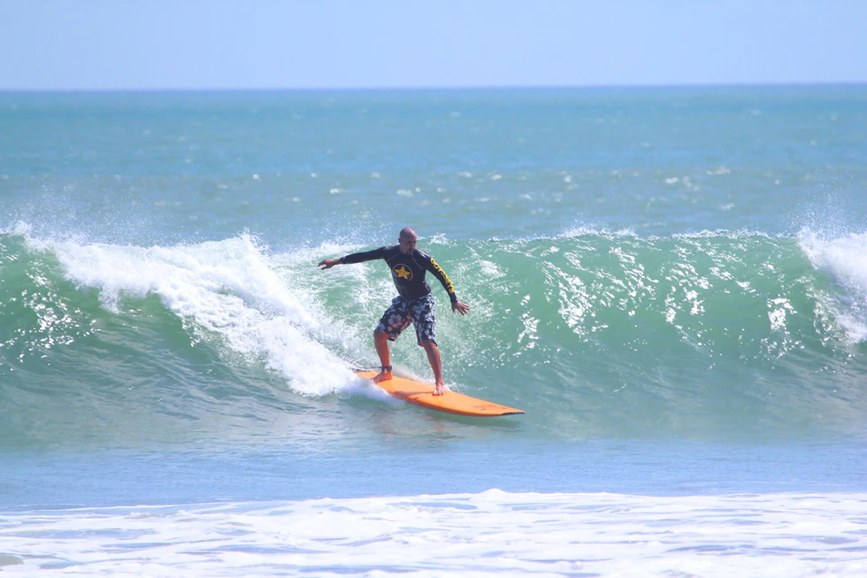 Riding a glassy green wave during an intermediated private surf lesson.