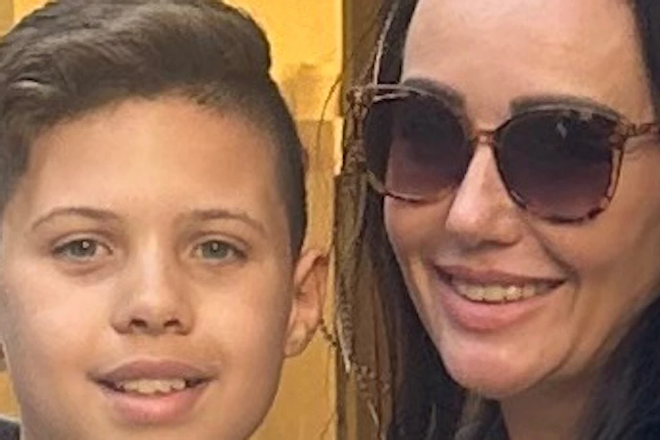 Mother and son standing near building