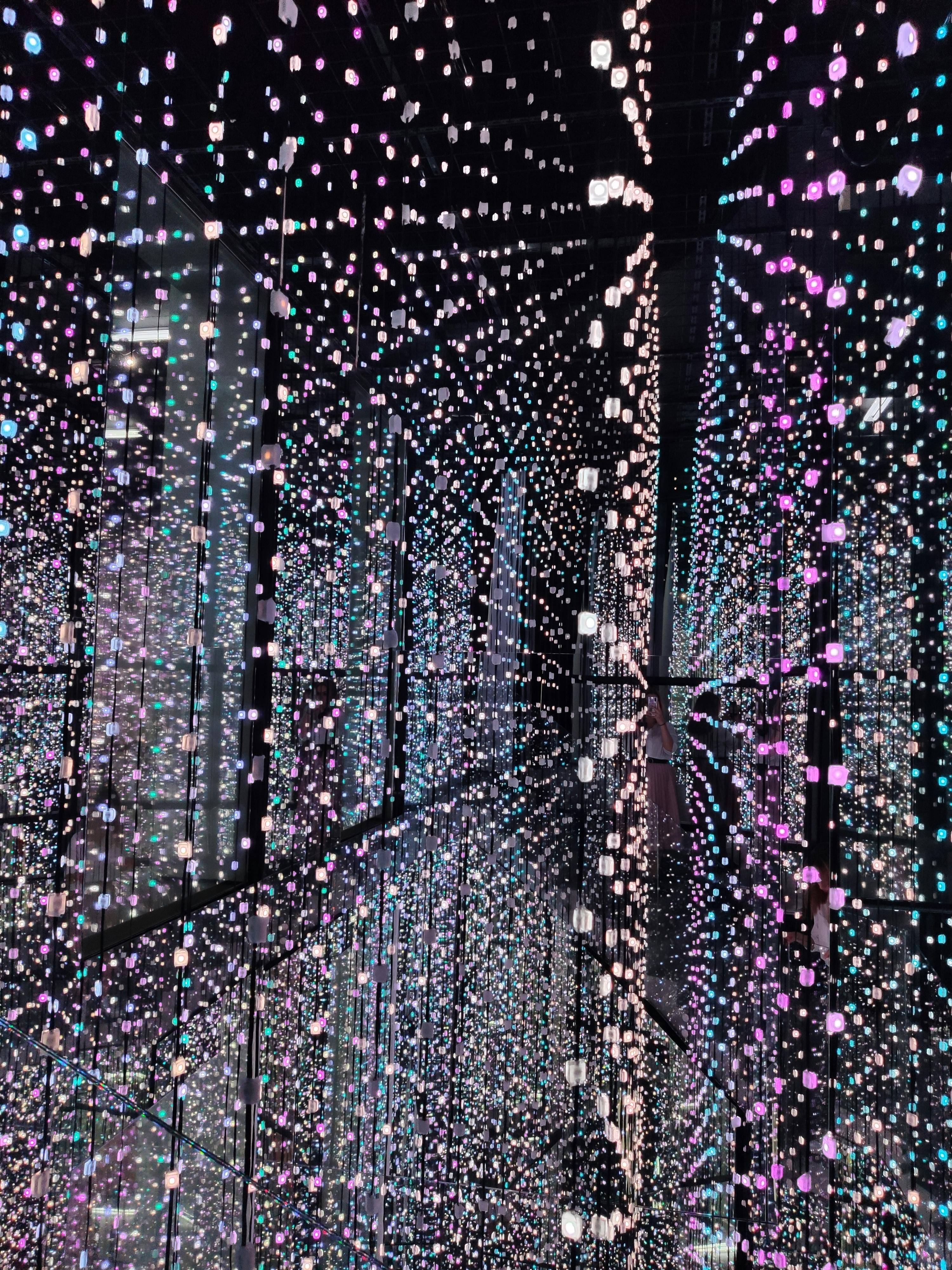 何百もの小さな多色のLEDライトがグリッドにぶら下がっており、反射で魅惑的で無限の効果を生み出しています。