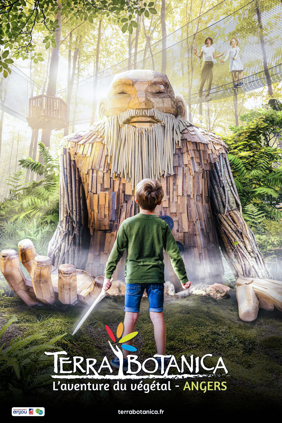 A boy with a toy sword stands in front of a large wooden humanoid sculpture in a lush, indoor garden with ferns and trees.
